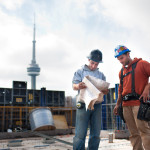 young architects looking at blue print